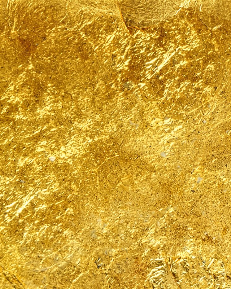 Crumpled gold leaf, bright and creased, catching the light across its folds.